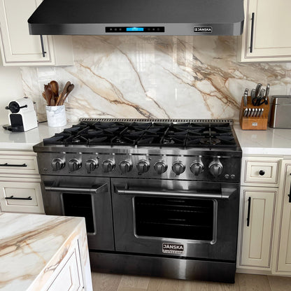 Stainless steel Janska gas range and  range hood in a kitchen with marble backsplash and countertops.