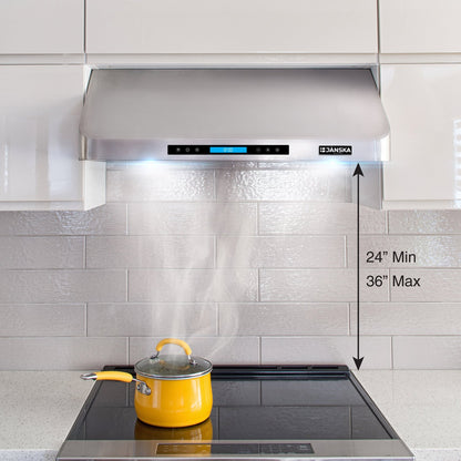 Janska range hood with a yellow pot on a stove, showing smoke and labeled dimensions.