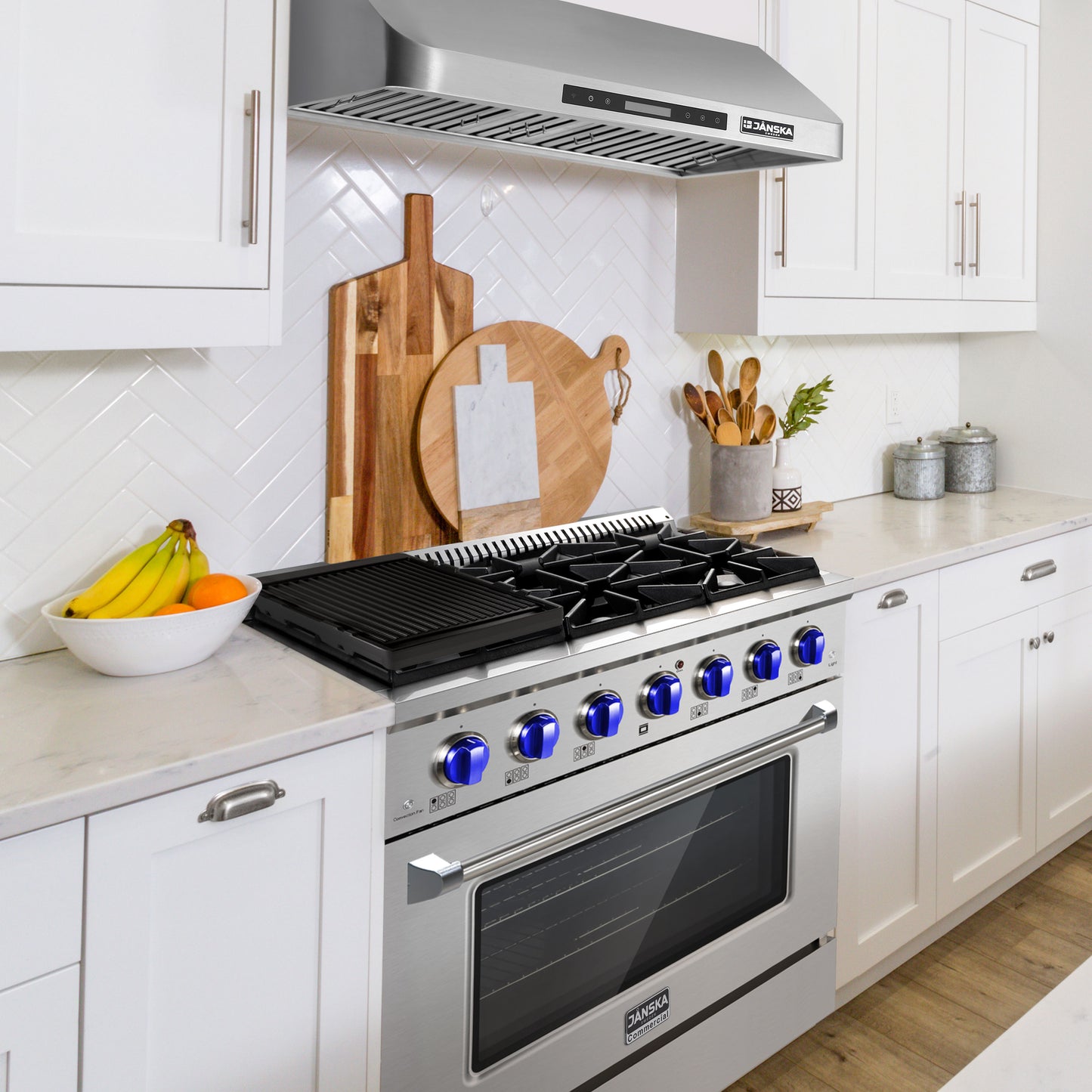 Modern kitchen with a stainless steel stove and oven, white cabinets, and decorative elements.